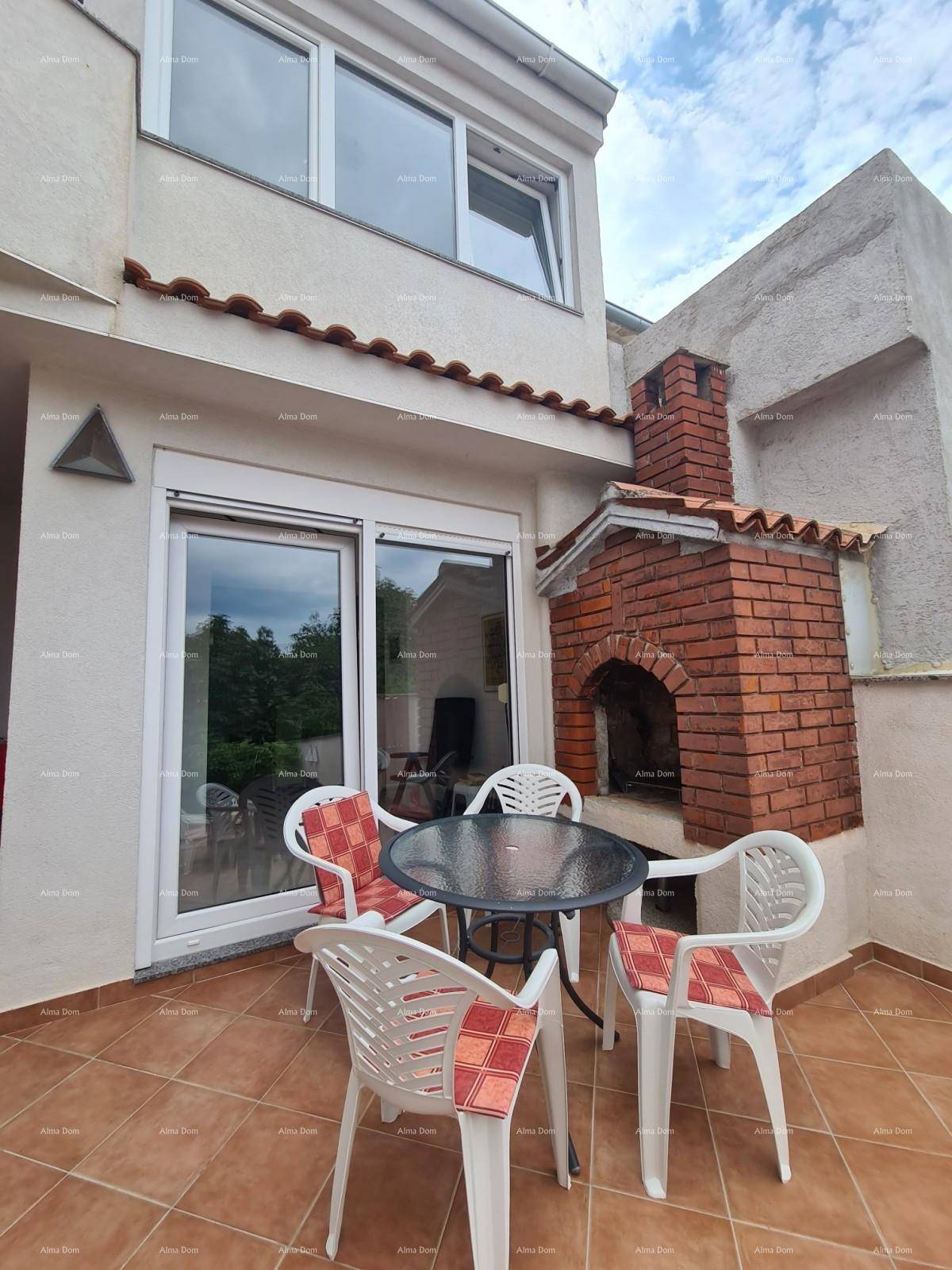 Gemütlicher Terrassenbereich mit Esstisch, Stühlen und gemauertem Grill, ideal für Mahlzeiten im Freien.