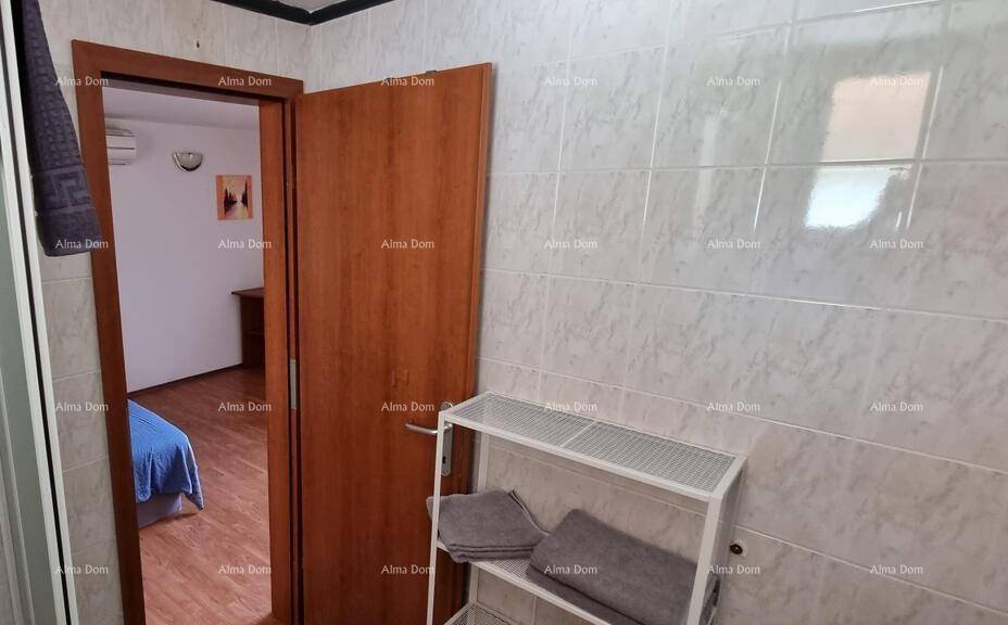 Gefliestes Badezimmer mit Blick auf die offene Tür zum angrenzenden Schlafzimmer.