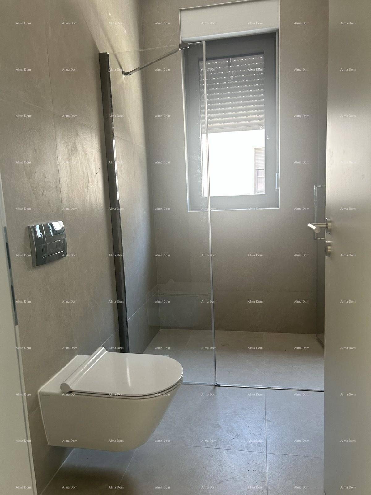 Modernes Badezimmer mit grauen Fliesen, wandhängendem WC und ebenerdiger Dusche mit Glaswand.