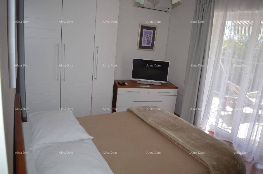 Helles Schlafzimmer mit Doppelbett, weißen Einbauschränken und Zugang zur Terrasse.