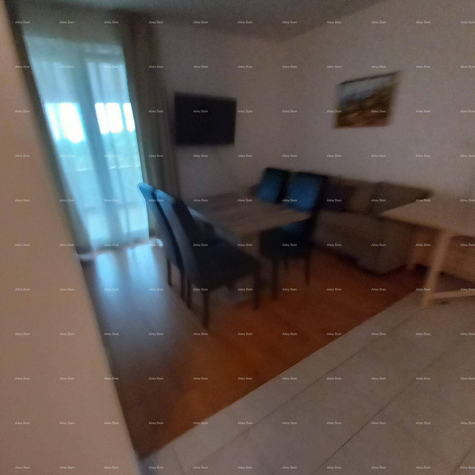 Unscharfer Blick in einen offenen Wohn-Essbereich mit Holzboden und Fernseher.
