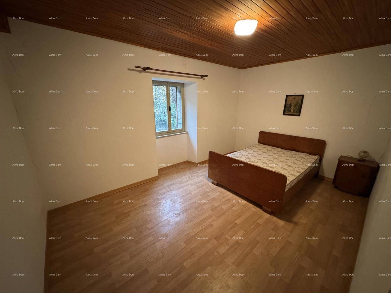 Schlafzimmer mit Holzbett, Nachttisch und Holzdecke, ausgestattet mit Parkettboden.