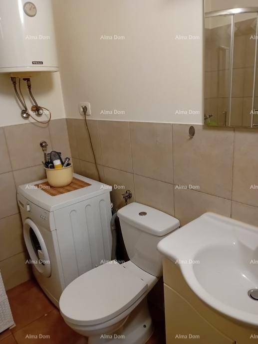 Kleines Badezimmer mit WC, Waschbecken, Fliesenboden und einer Waschmaschine.
