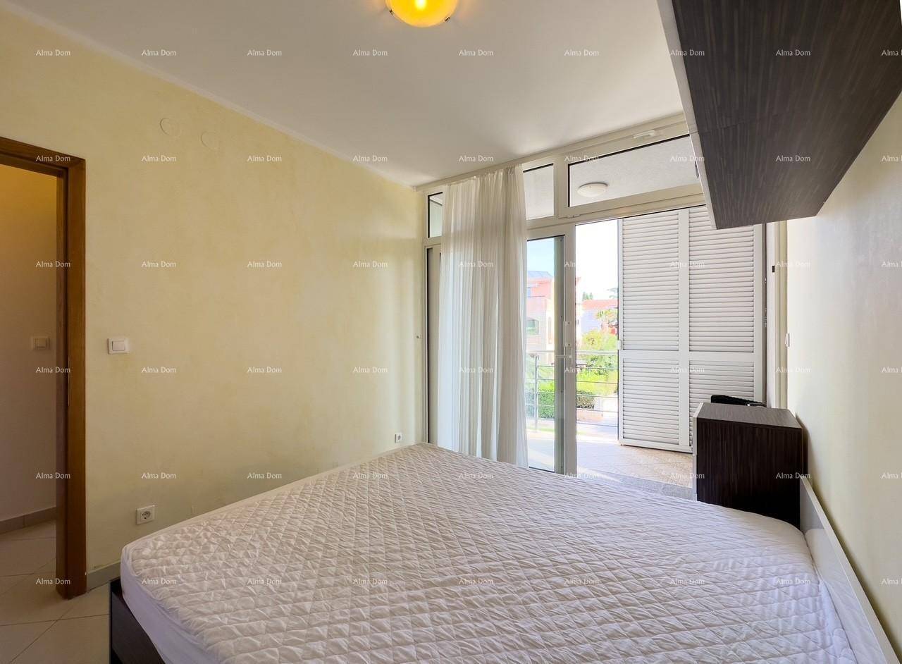 Schlafzimmer mit Balkonzugang, der einen Blick ins Grüne und viel Tageslicht bietet.