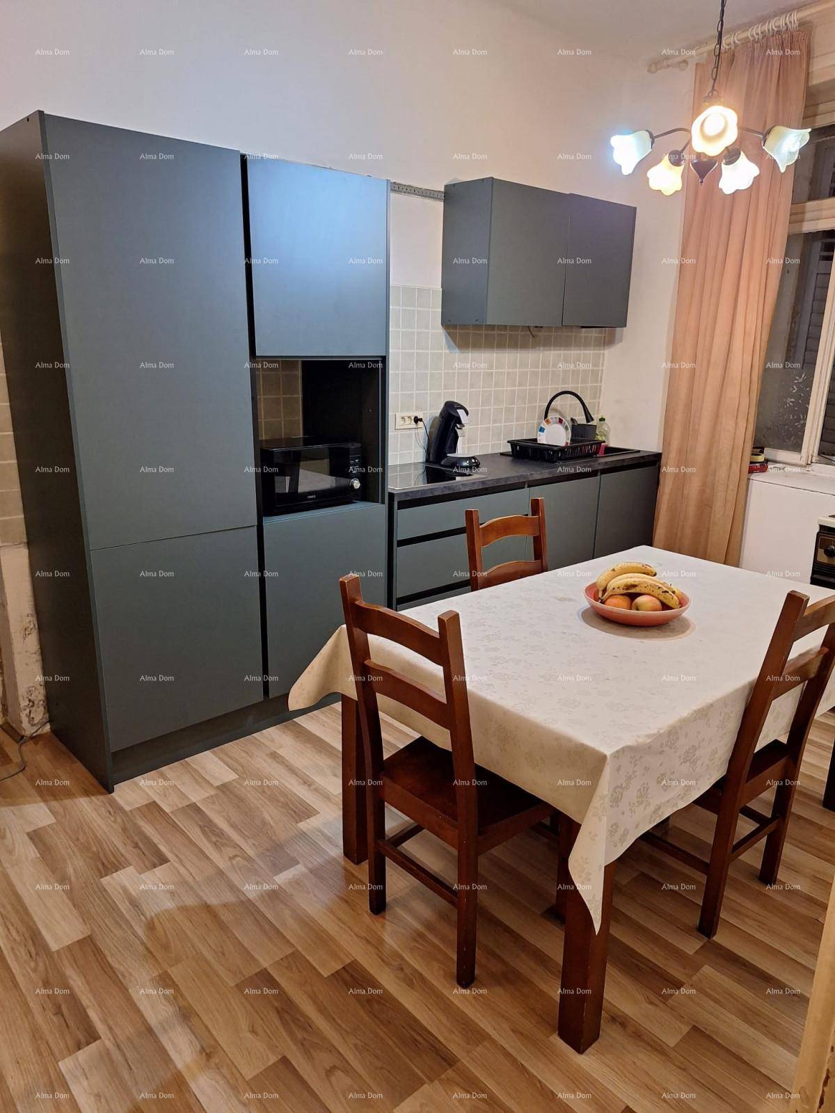 Moderne Küche mit dunklen Schränken, Esstisch und integrierten Geräten.