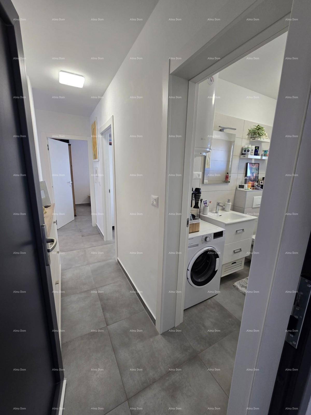 Heller Flur mit grauen Fliesen, der zu einem Badezimmer und weiteren Räumen führt.