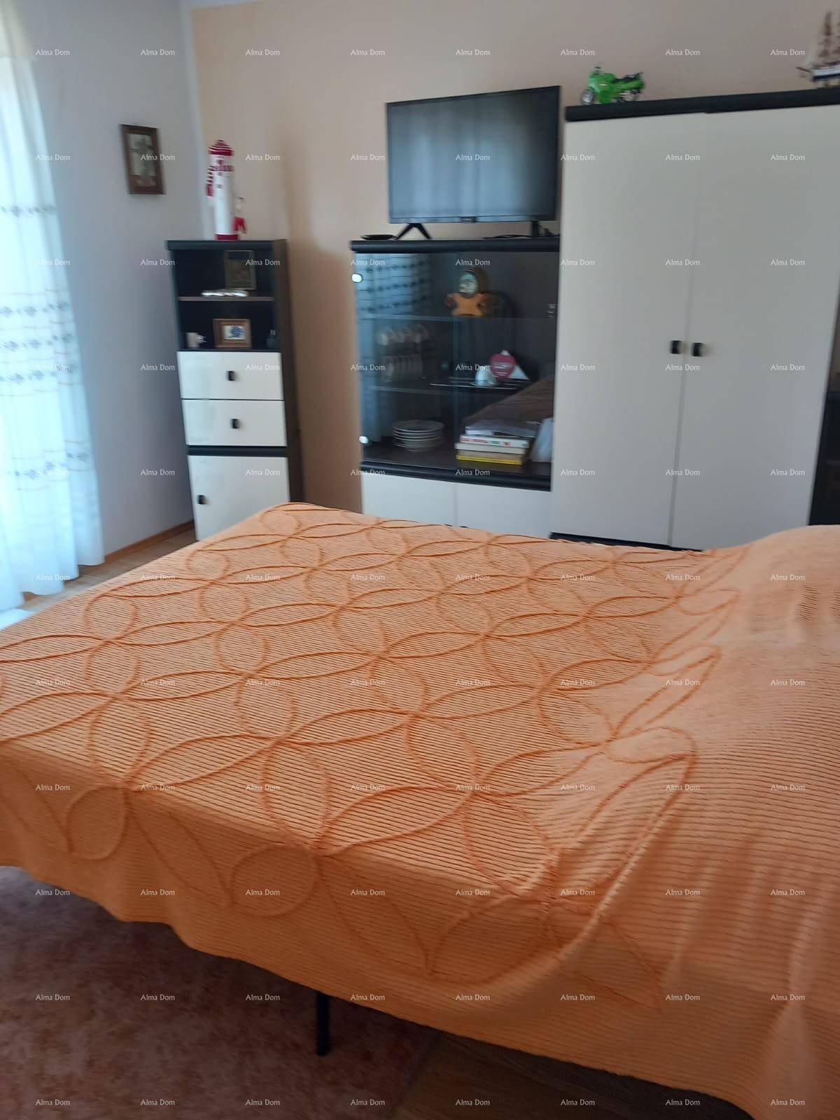Schlafzimmer mit Bett, Fernseher und Kleiderschrank, bietet Komfort und Stauraum.