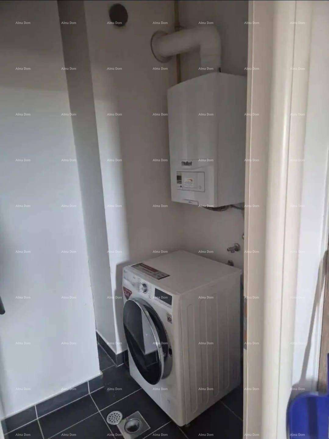Praktischer Hauswirtschaftsraum mit Waschmaschine und Warmwasserbereiter.