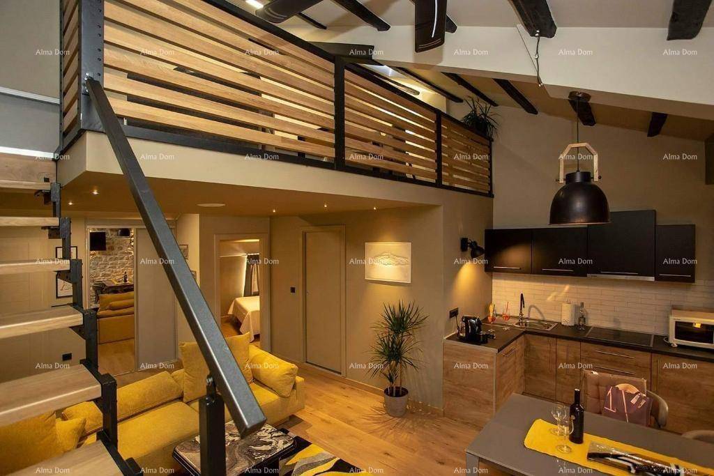 Offener Wohnbereich mit gelbem Sofa, integrierter Küche und Treppe zur Schlafgalerie unter sichtbaren Holzbalken.