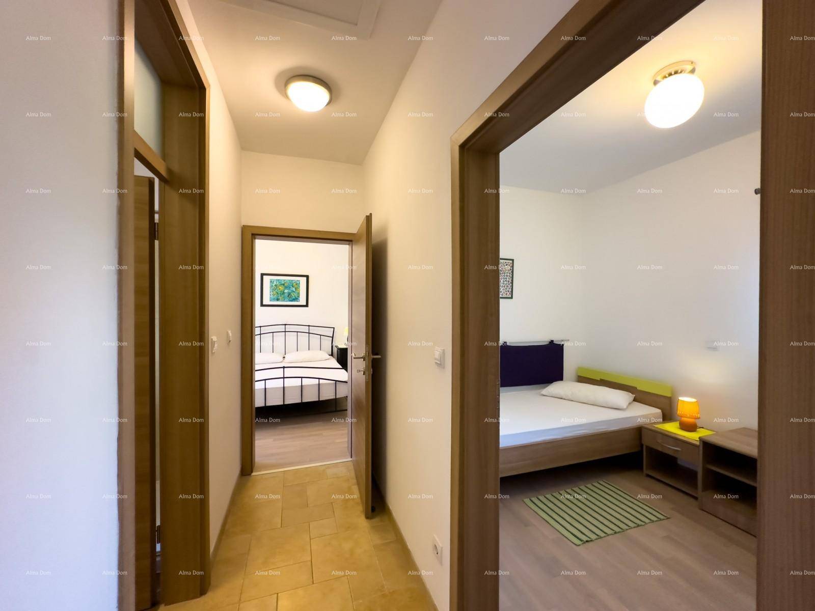 Flur mit Fliesenboden und Blick in zwei helle Schlafzimmer mit Laminatboden.