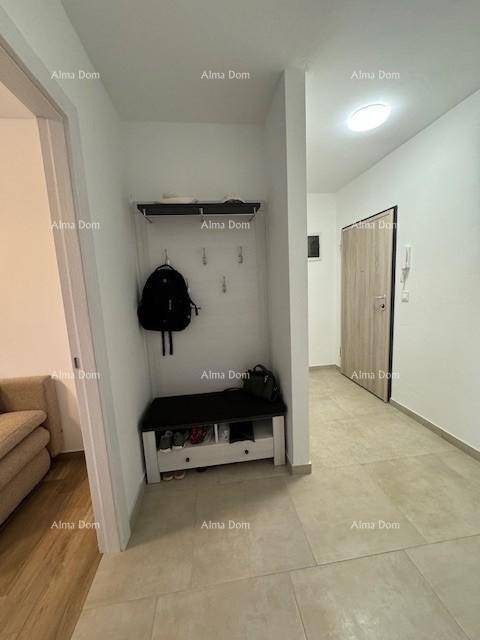 Eingangsbereich mit Fliesenboden und Garderobe, die Platz für Jacken und Schuhe bietet.