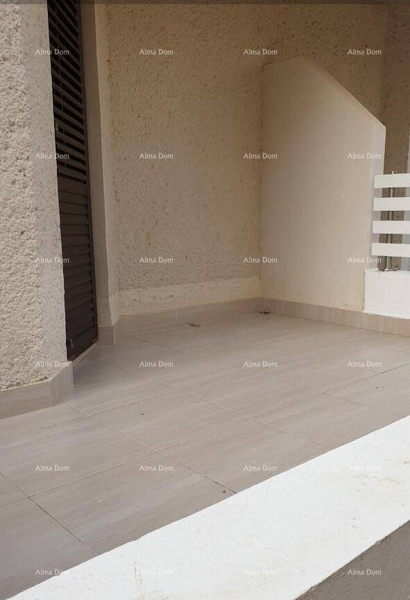 Leere, geflieste Terrasse mit schlichten Wänden und einem Zugang zum Gebäude.