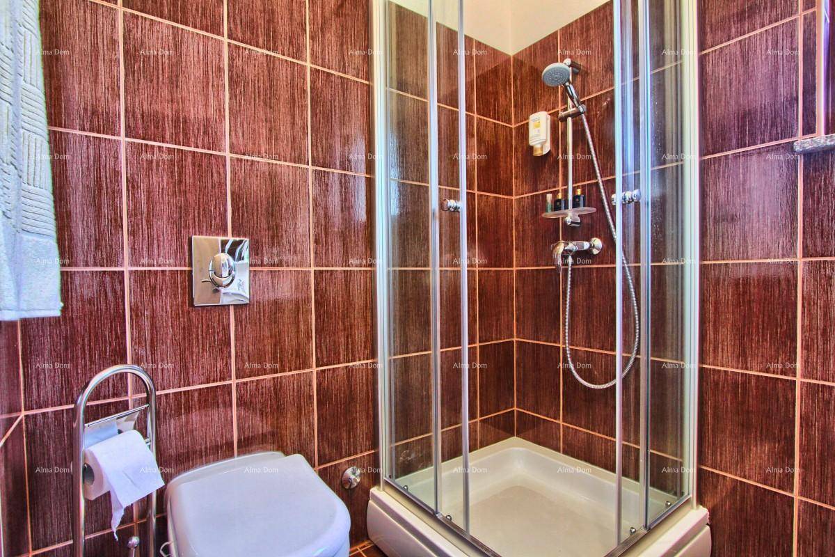 Badezimmer mit braunen Fliesen, einer Eckdusche und einer Toilette.