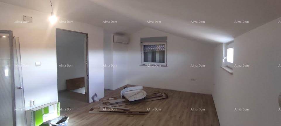 Dachgeschosszimmer mit schräger Decke, Holzboden und Fenster, derzeit im Ausbau.