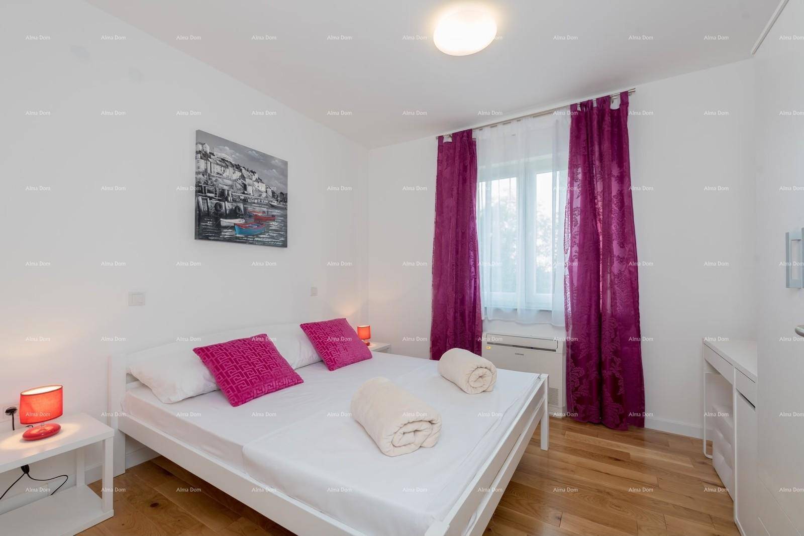 Helles Schlafzimmer mit Doppelbett, Nachttischen und lila Vorhängen.