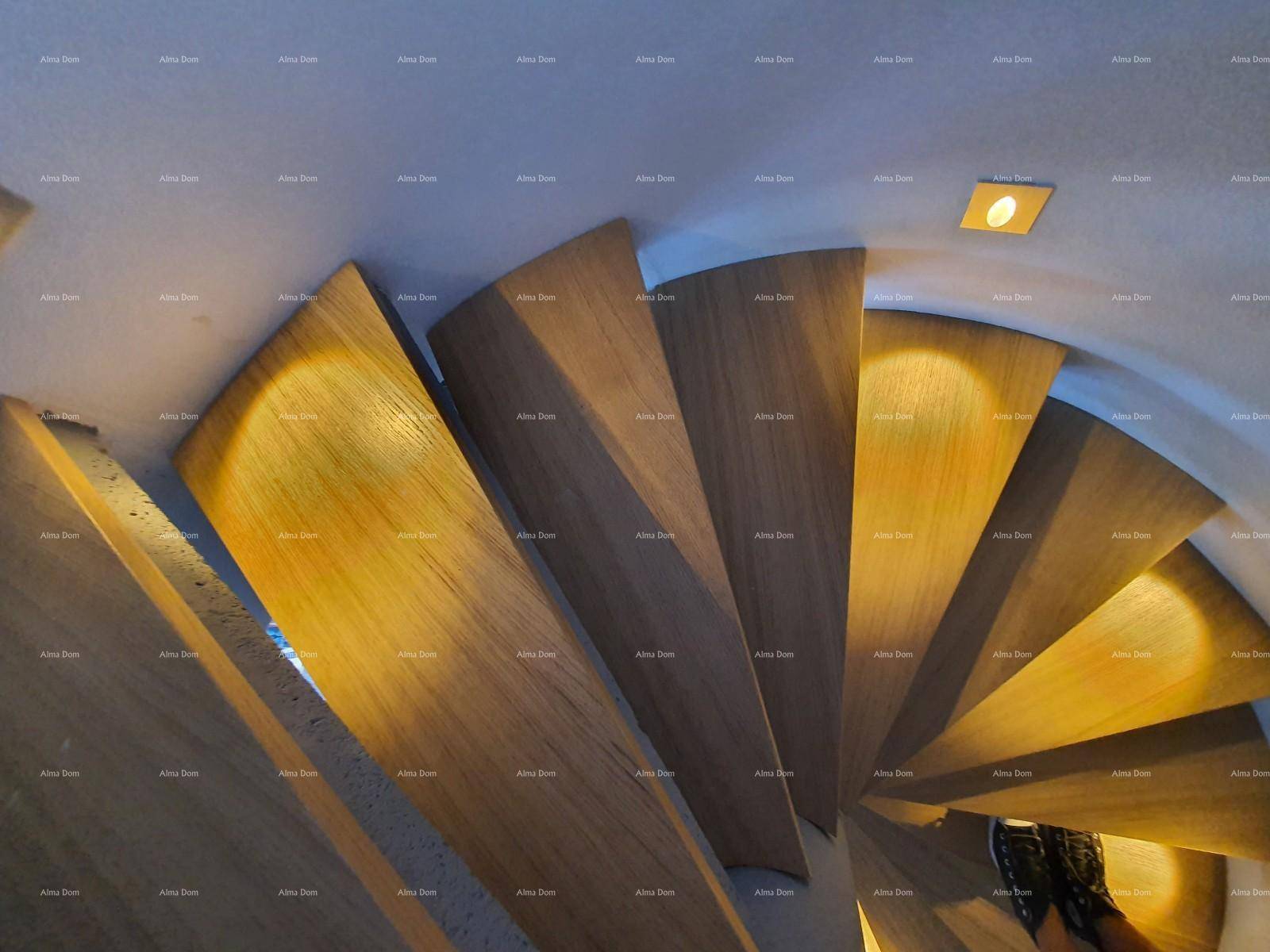 Elegante Holztreppe mit indirekter Beleuchtung, die die verschiedenen Ebenen des Hauses verbindet.