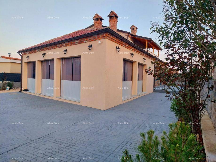 Traditionelles Gebäude mit heller Fassade, Ziegeldach und mehreren Schornsteinen.