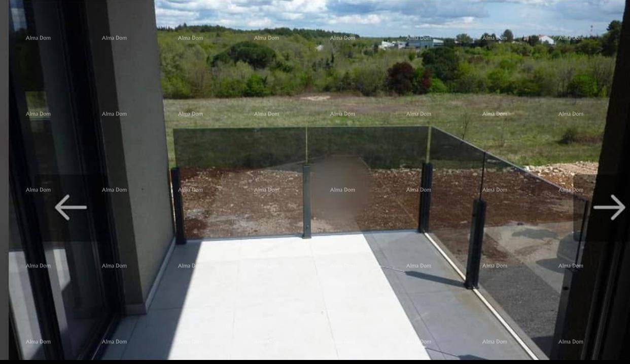 Geräumige Terrasse mit Fliesenboden, Glasgeländer und weitem Blick auf die Landschaft.