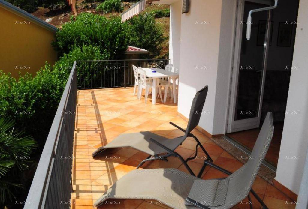 Heller Balkon mit Fliesenboden, Sonnenliegen und einem Esstisch für Mahlzeiten im Freien.