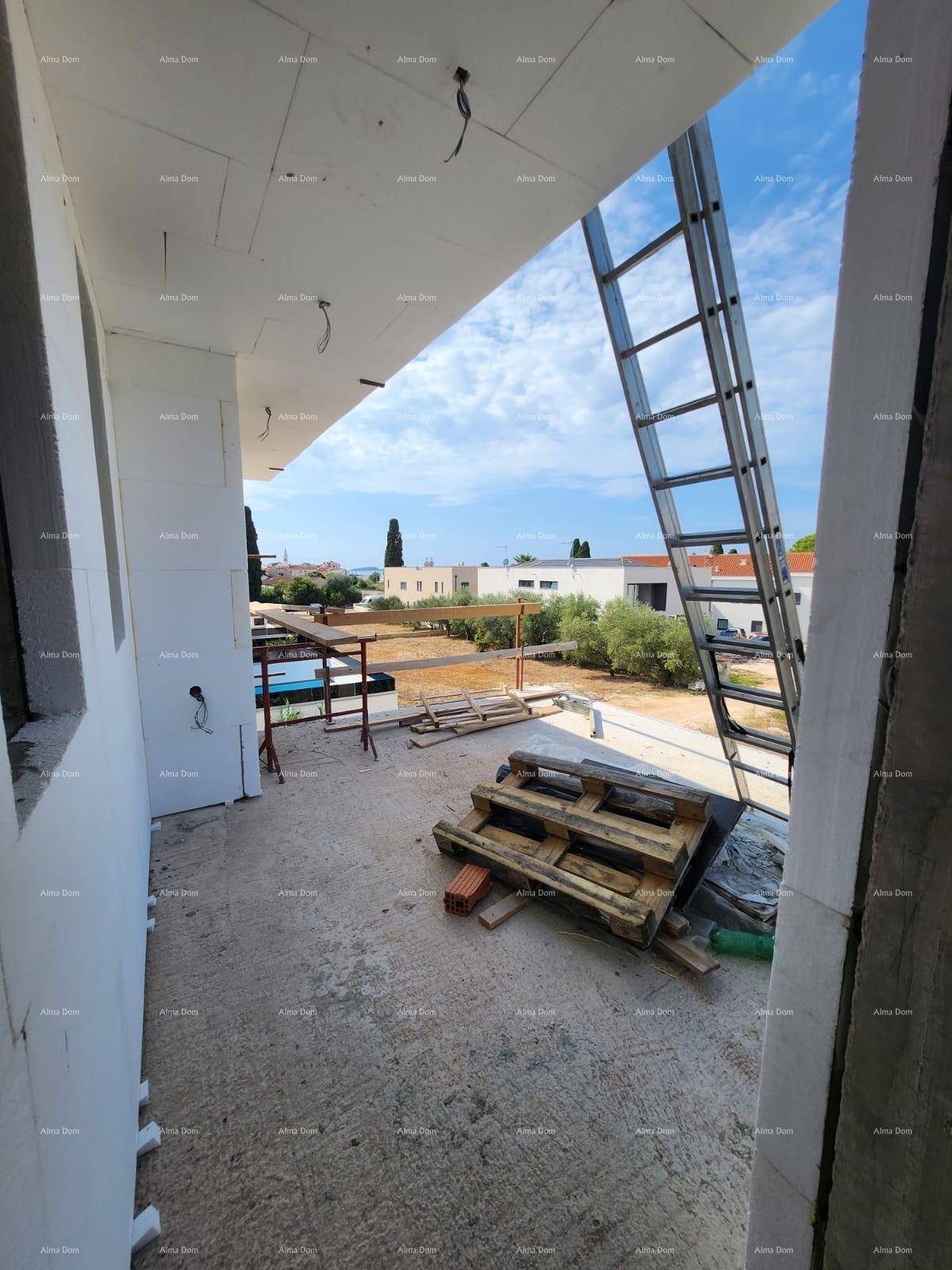 Blick von einem im Bau befindlichen Balkon auf die Umgebung mit weiteren Gebäuden und Bäumen.