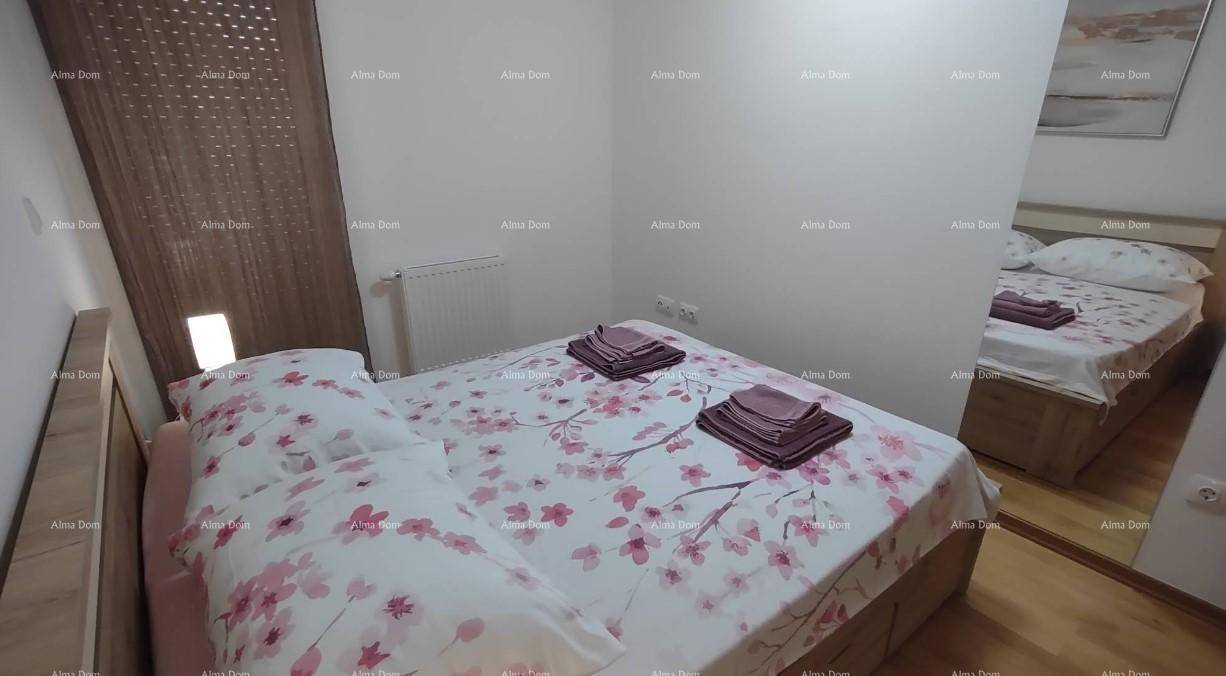 Freundliches Schlafzimmer mit floraler Bettwäsche, Holzmöbeln und einem großen Spiegel.