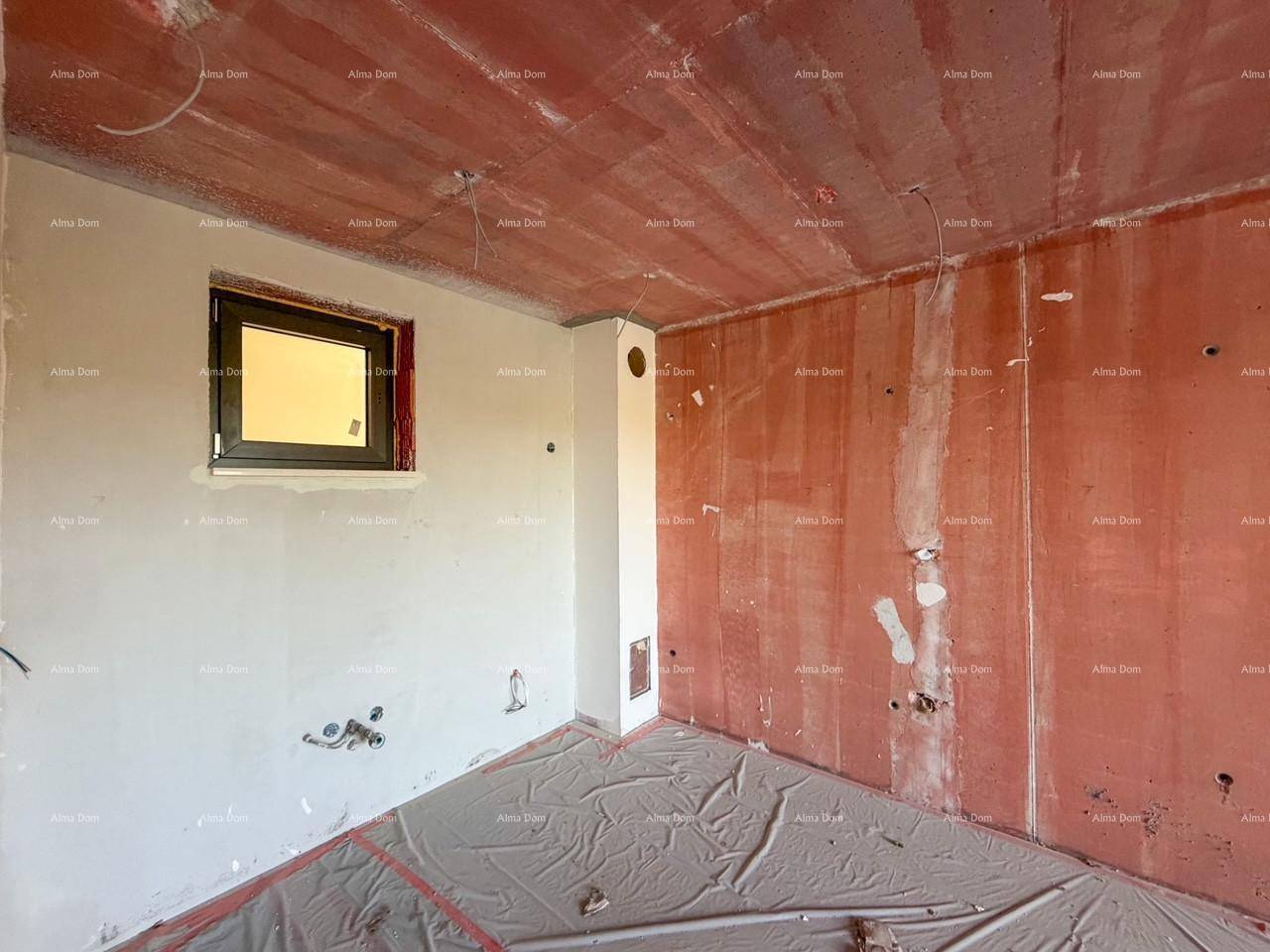 Unfertiger Raum im Rohbau mit einem kleinen Fenster und sichtbaren Installationen.