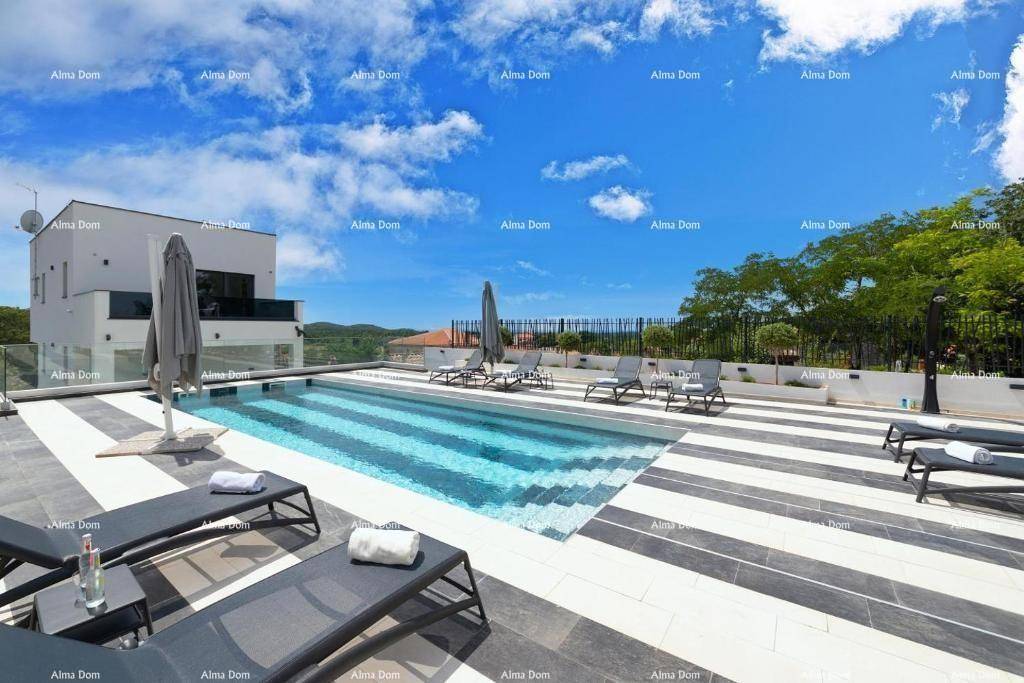 Weitläufiger Poolbereich mit modernen Fliesen, bequemen Liegestühlen und Panoramablick.
