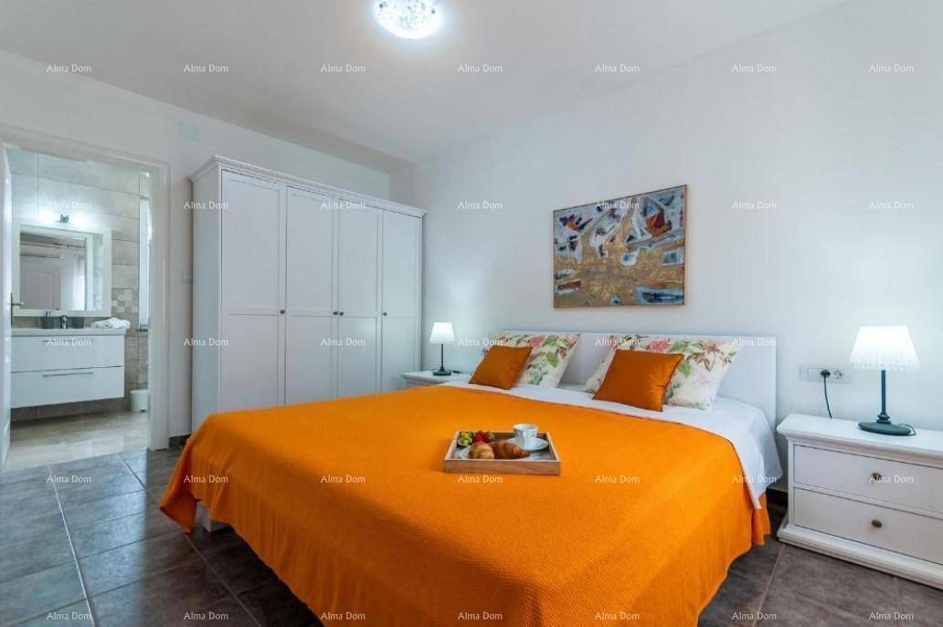 Helles Schlafzimmer mit großem Bett, weißem Kleiderschrank und Zugang zum Badezimmer.