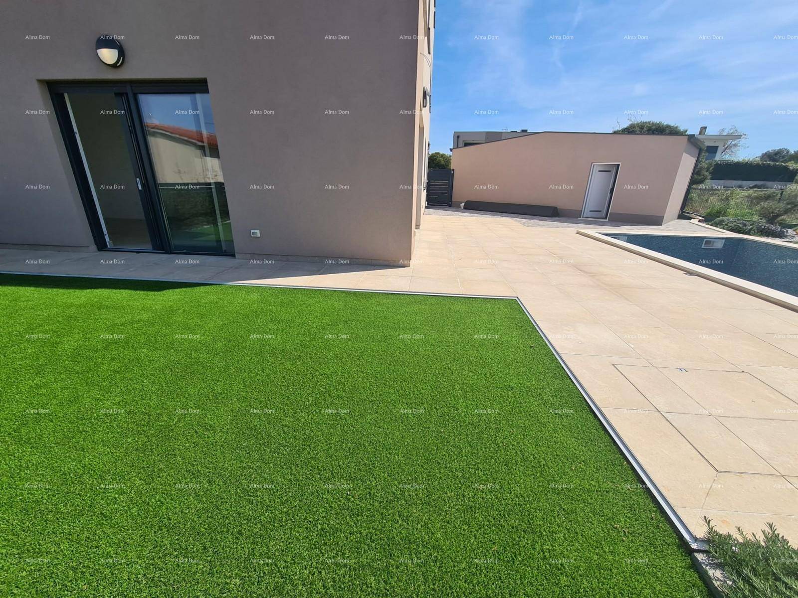Weitläufige Rasenfläche neben dem Gebäude mit Zugang zum Poolbereich unter blauem Himmel.