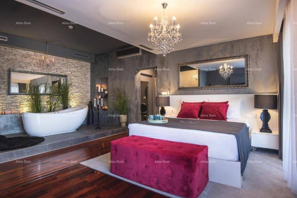 Luxuriöses Schlafzimmer mit freistehender Badewanne, Steinwandakzenten und elegantem Holzboden.