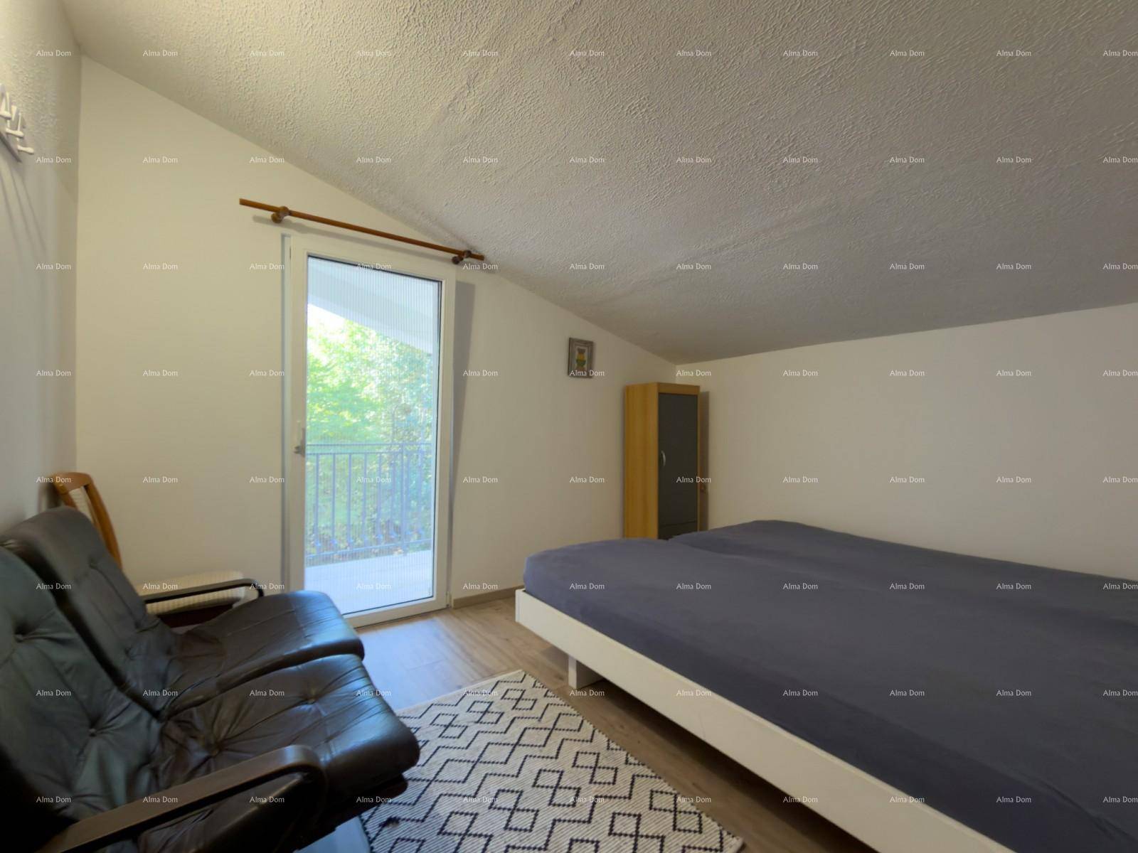 Schlafzimmer mit Doppelbett, Sofa und Zugang zu einem Balkon.