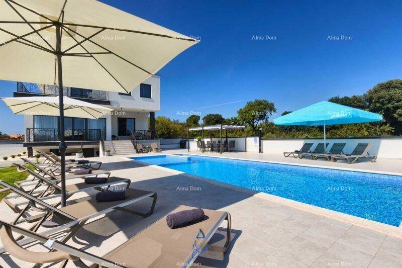 Großer Außenpoolbereich mit Sonnenliegen und Sonnenschirmen unter blauem Himmel.