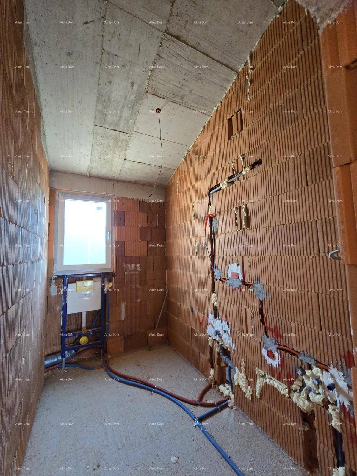 Badezimmer im Rohbau mit Fenster, Ziegelwänden und vorbereiteten Sanitärinstallationen.
