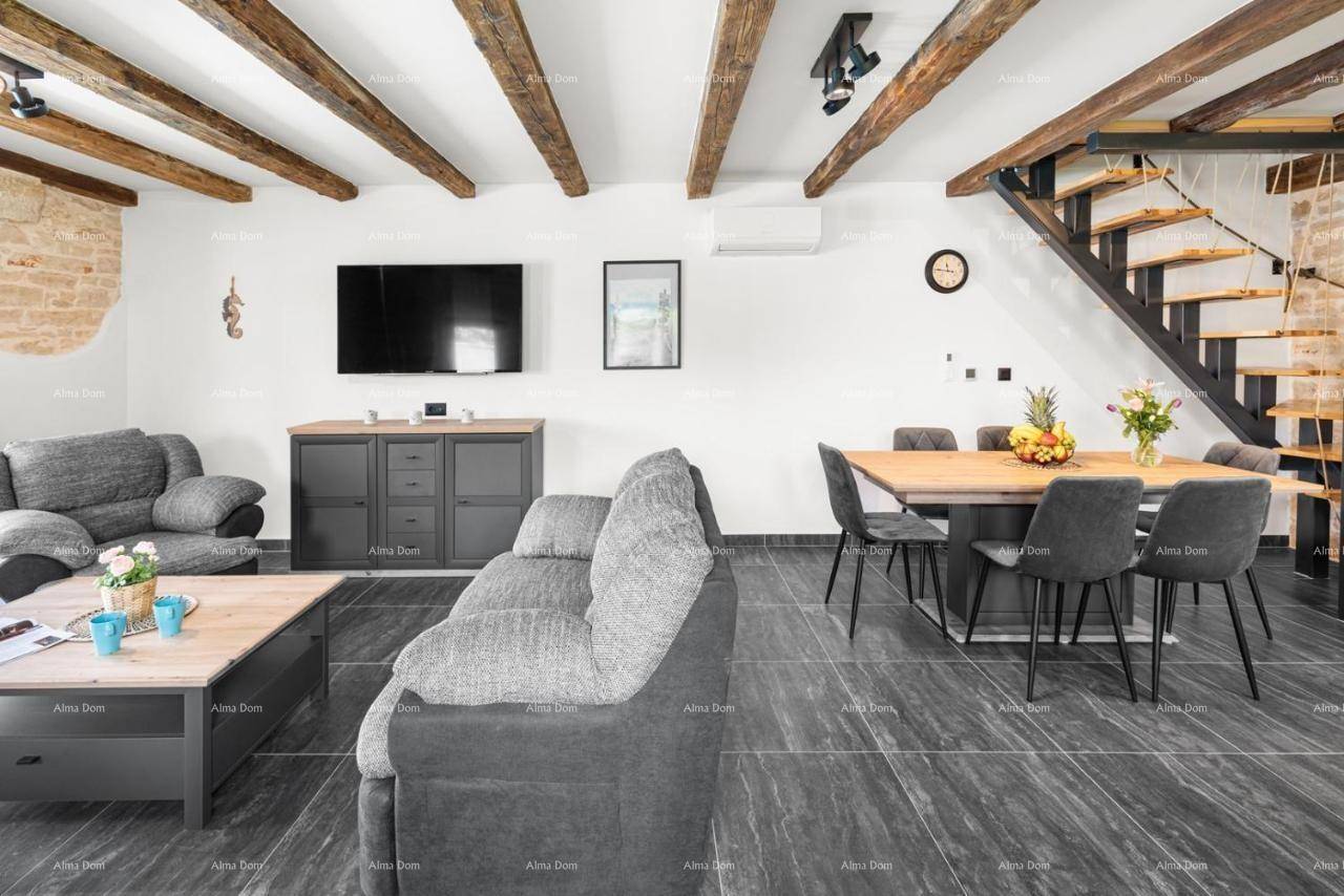 Geräumiger offener Wohn-Essbereich mit bequemen Sofas, Holztisch und freiliegenden Holzbalken.