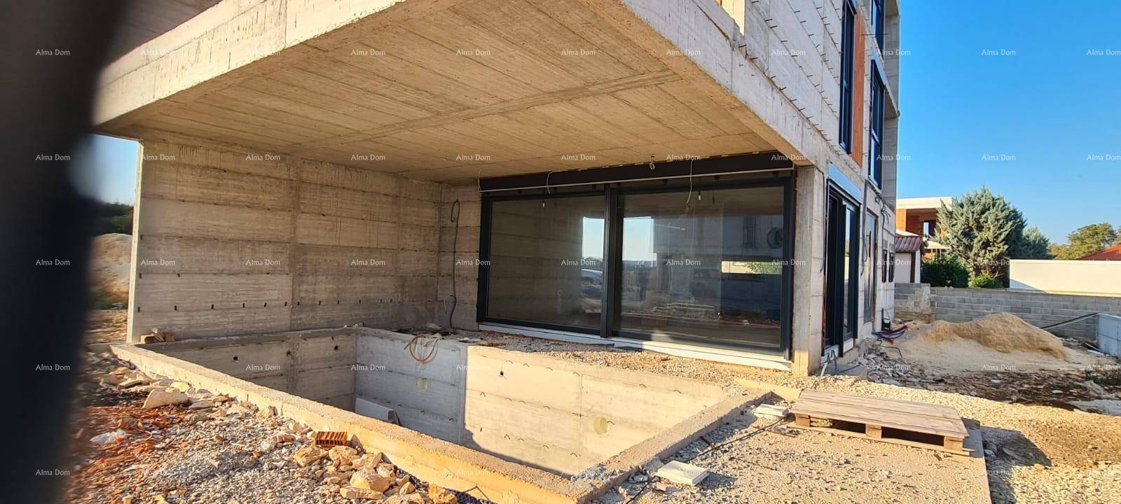 Detailansicht des Erdgeschosses des Rohbaus mit großen Schiebetüren und Baugrube.