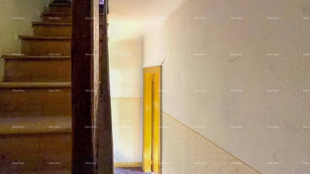 Treppenhaus mit Holztreppe und gelber Tür, die zu einem weiteren Raum im Haus führt.