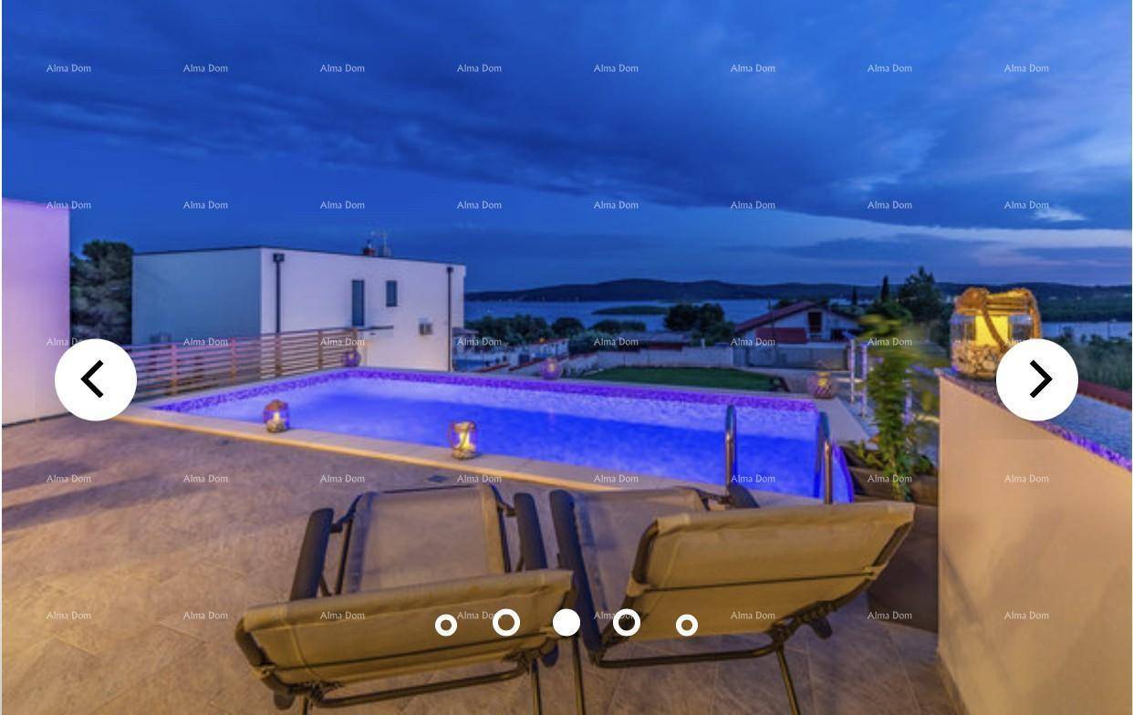 Beleuchteter Pool und Terrasse bei Nacht, mit entspannter Atmosphäre und Meerblick.