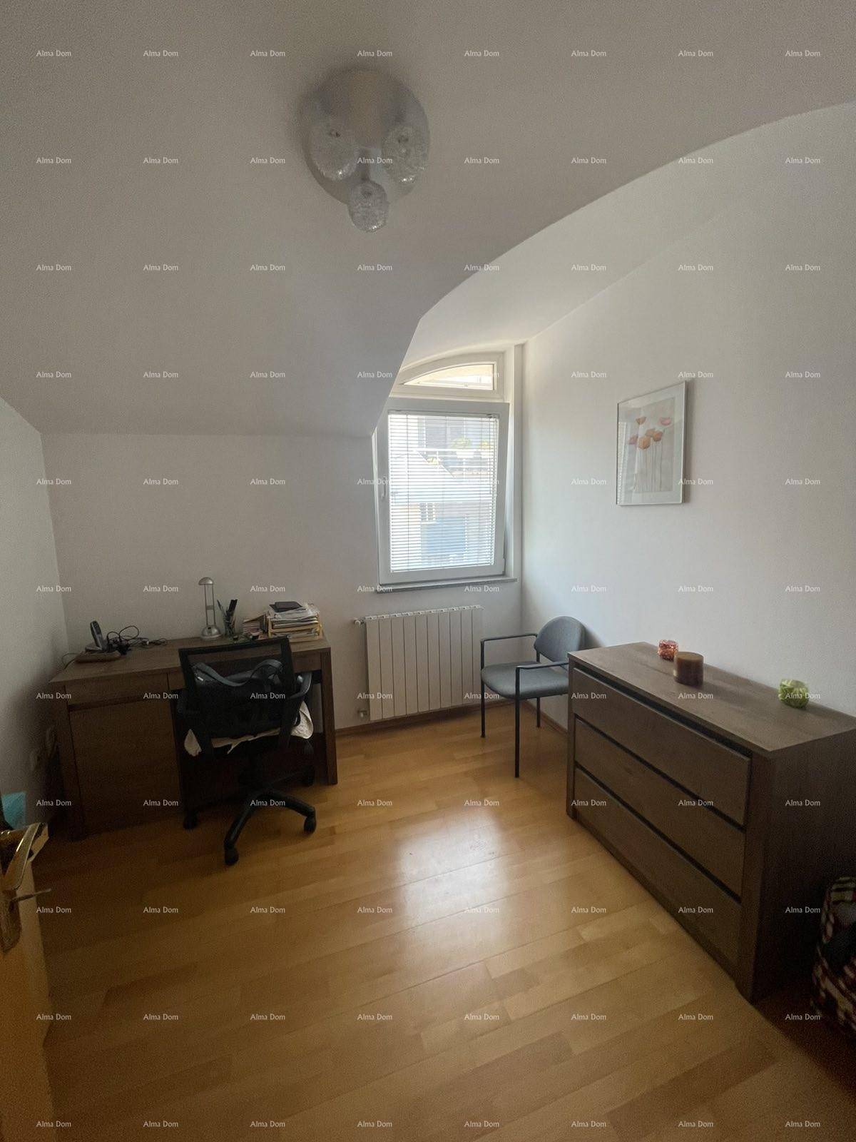 Funktionales Arbeitszimmer mit Holzboden, Schreibtisch und Stauraum unter der Dachschräge.