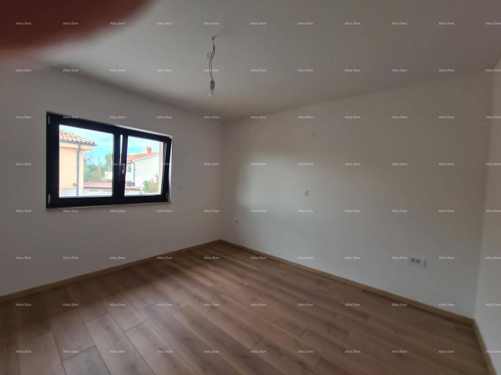 Schlafzimmer mit hellem Holzboden und einem Fenster, das viel Tageslicht hereinlässt.
