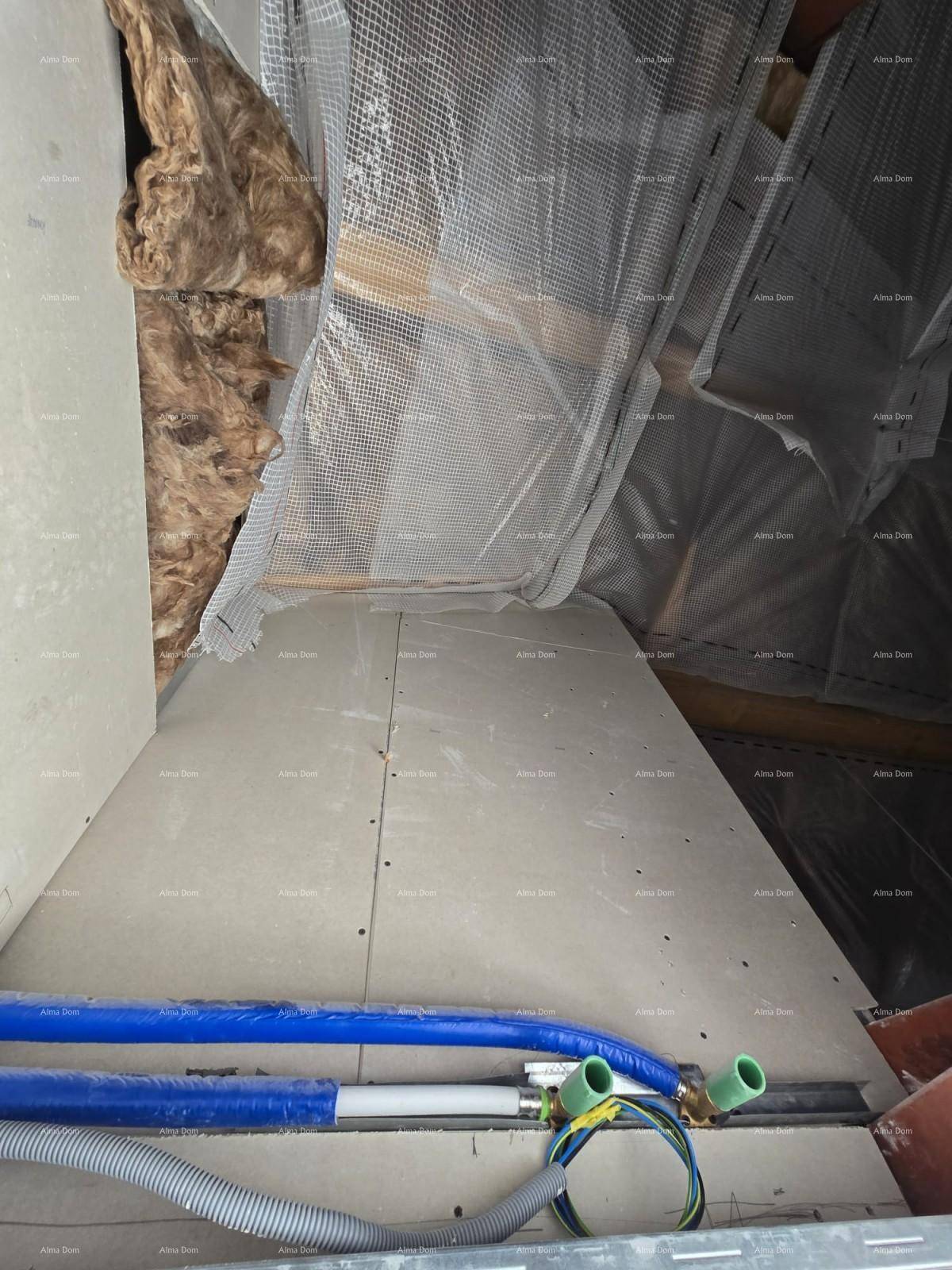 Unfertiger Dachbodenbereich mit Isolierung und sichtbaren Installationen im Rohbauzustand.