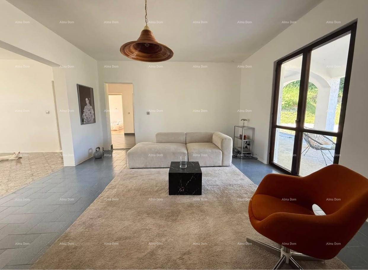 Geräumiges Wohnzimmer mit großem Sofa, Teppich und Zugang zu einem Außenbereich.