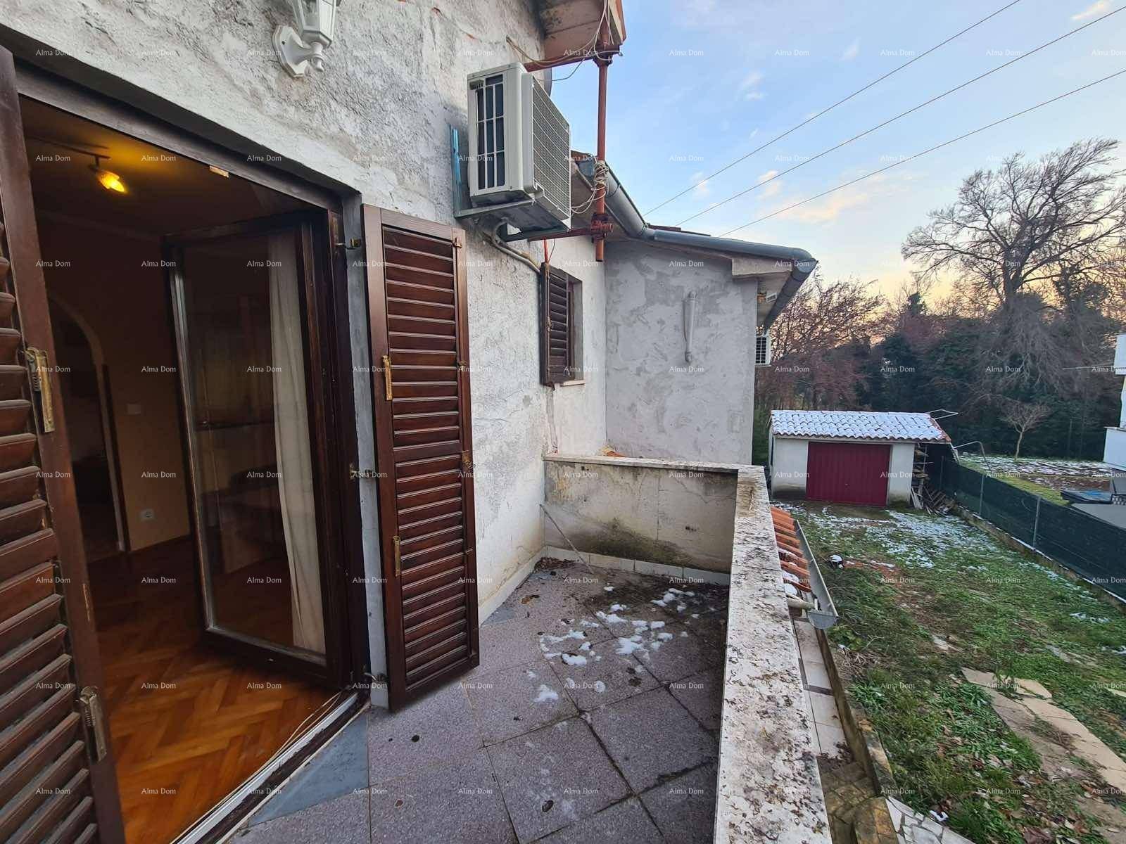 Balkon mit Betonboden, Klimaanlage und Blick auf den Gartenbereich.