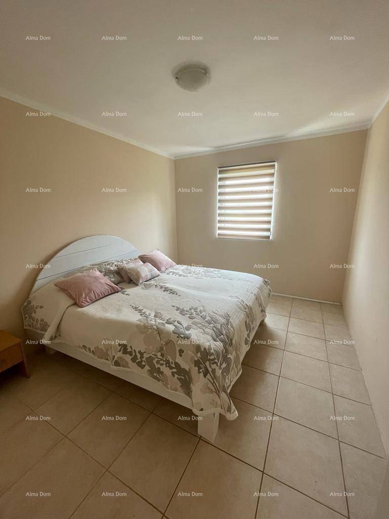 Gemütliches Schlafzimmer mit Doppelbett, beigen Fliesen und einem Fenster mit Jalousien.