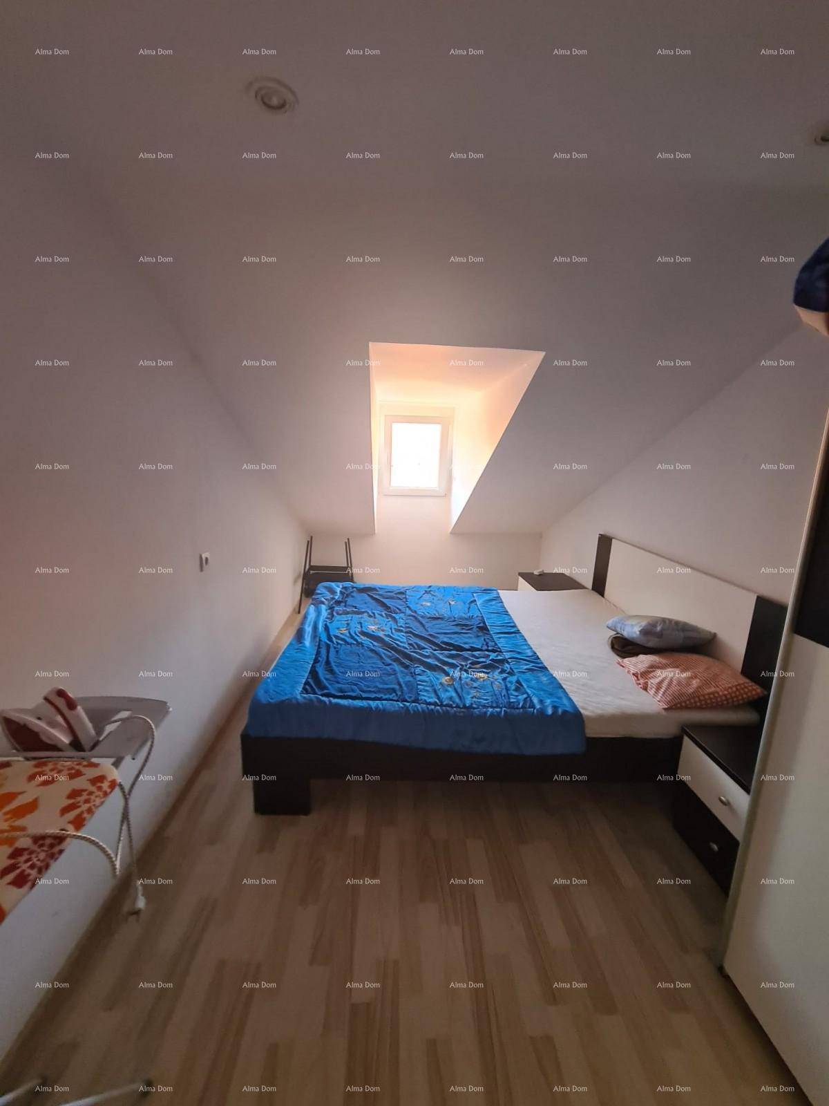 Gemütliches Schlafzimmer im Dachgeschoss mit Bett, Nachttischen und einem kleinen Dachfenster.