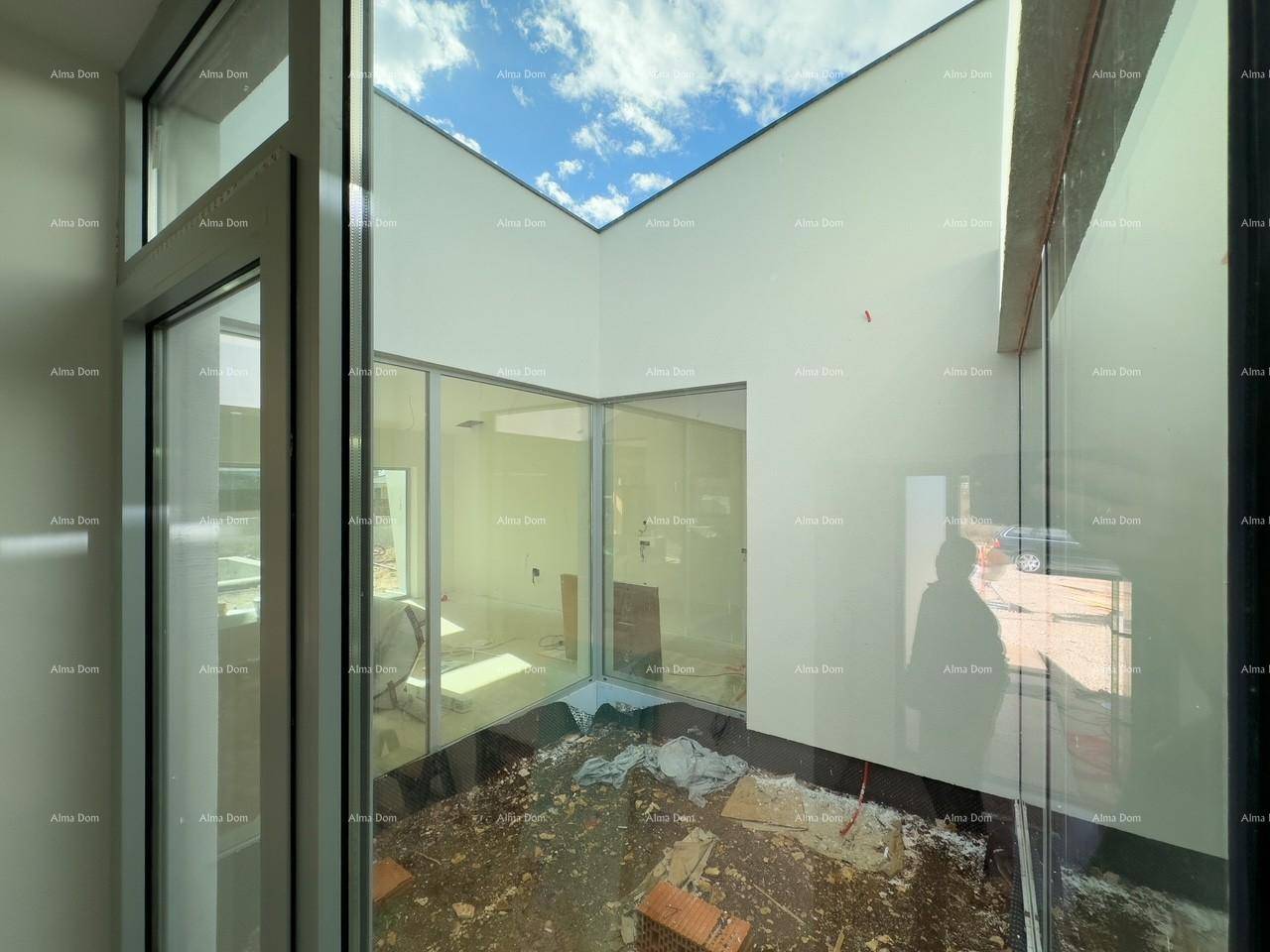Innenhof oder Lichtschacht mit Glaswänden, der Tageslicht in das Gebäude bringt und eine moderne Architektur zeigt.