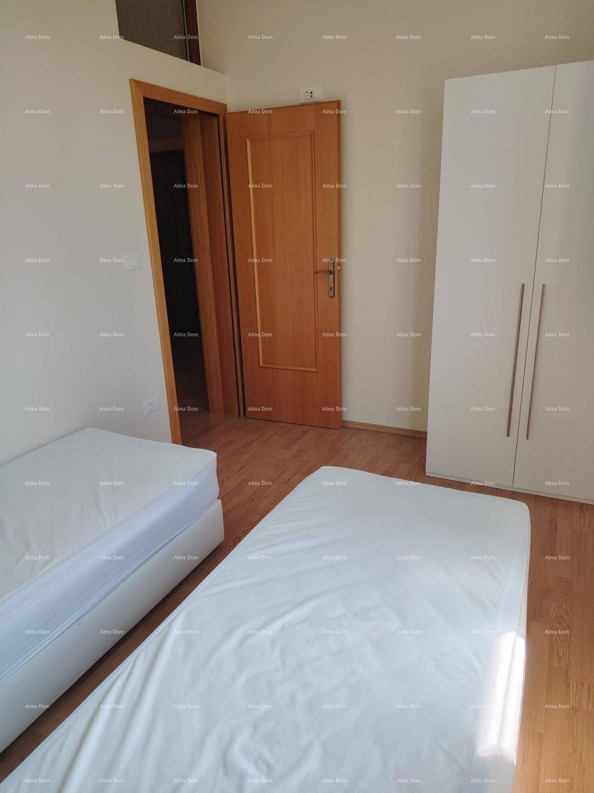 Schlafzimmer mit zwei Einzelbetten, weißem Kleiderschrank und Holztür, bietet eine einfache Einrichtung.
