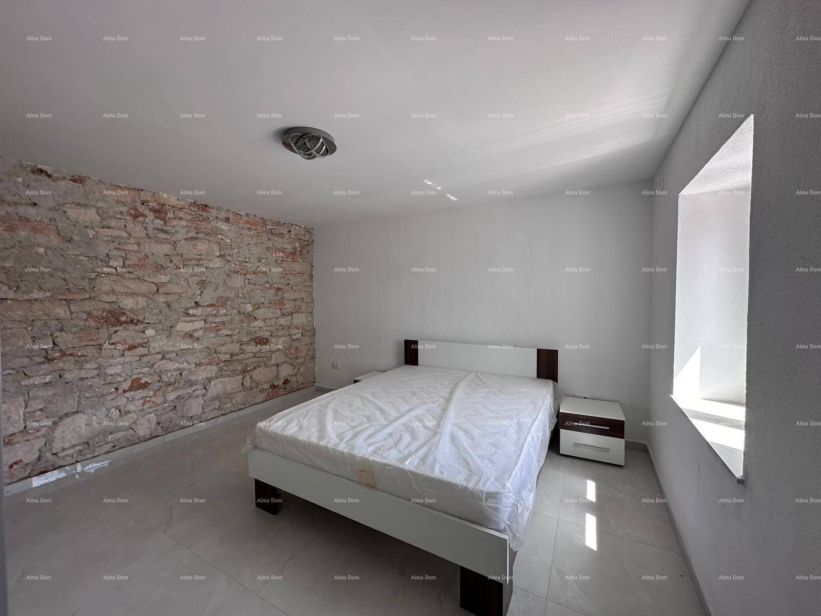 Schlafzimmer mit Doppelbett, Nachttischen und einer rustikalen Steinwand als Akzent.