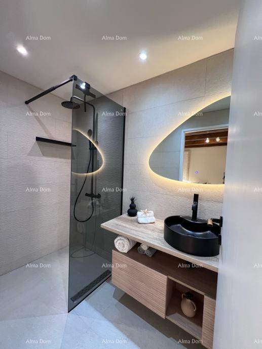 Elegantes Badezimmer mit begehbarer Dusche, modernem Waschbecken und beleuchtetem Spiegel in ovaler Form.