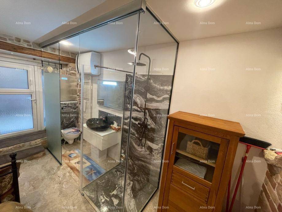 Modernes Badezimmer mit begehbarer Dusche, schwarzem Waschbecken und wandhängendem WC, abgetrennt durch Glas.