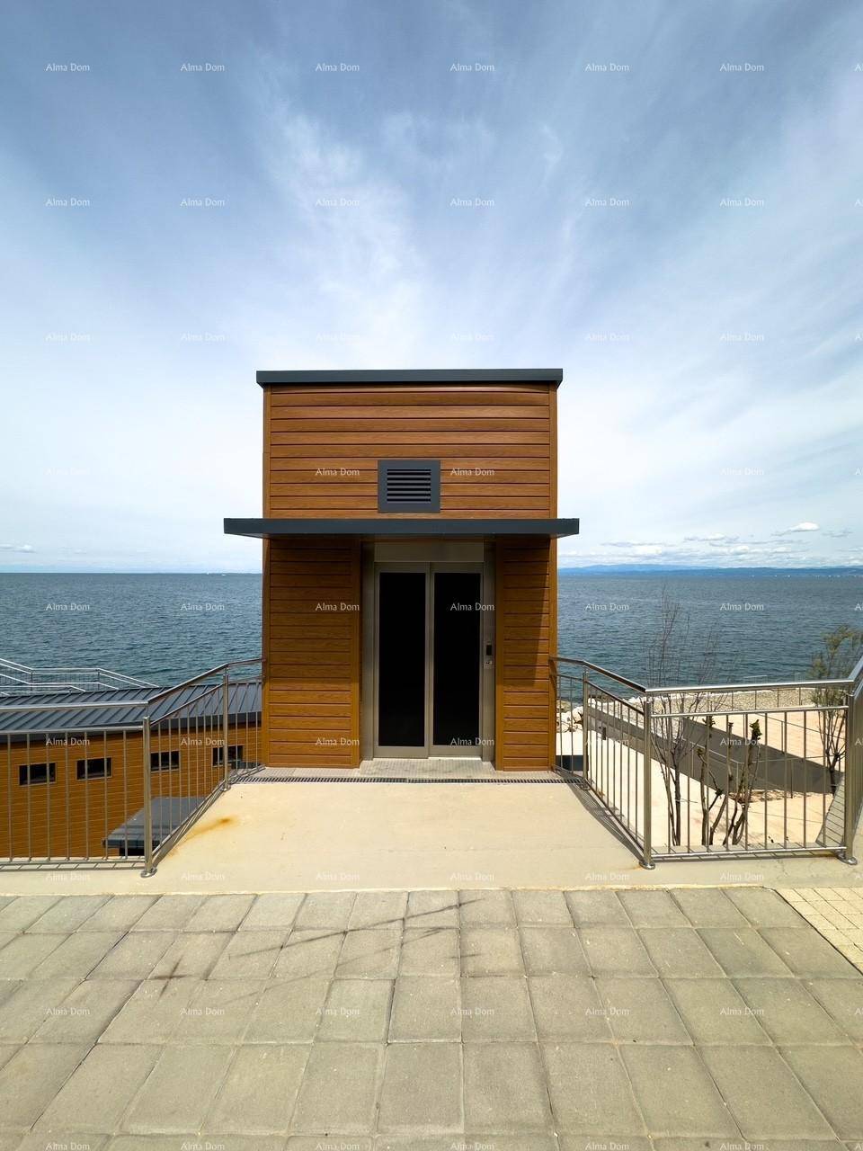 Modernes Gebäude mit Holzfassade und Glasfront, direkt am Meer gelegen.